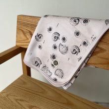 Load image into Gallery viewer, folded jersey baby blanket in gender neutral shell print hanging over back of a chair