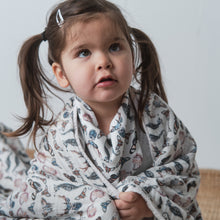 Load image into Gallery viewer, girl with pigtails wrapped in butterfly deer shell and seahorse patterned cotton toddler blanket