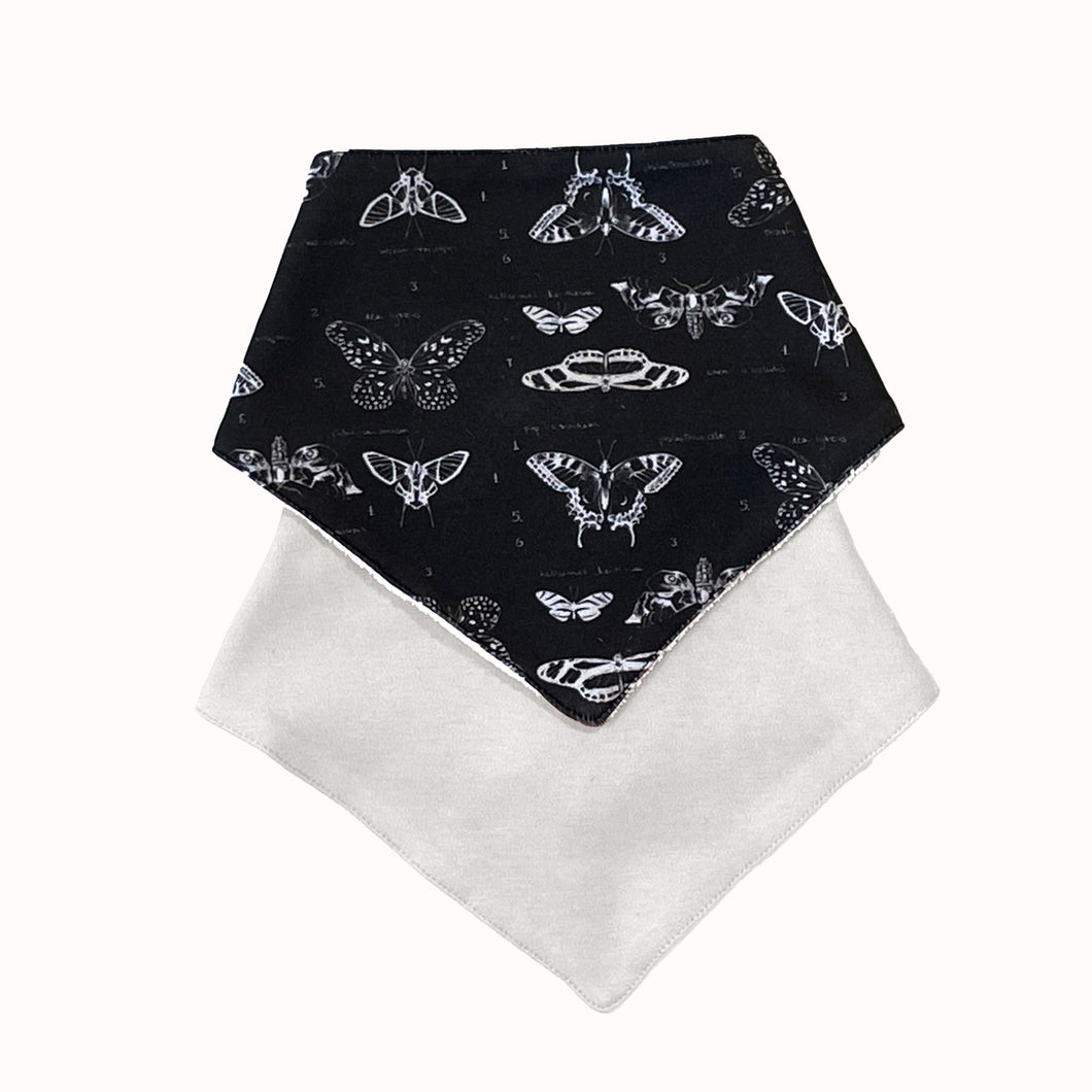 Set of 2 GOTS certified organic jersey cotton bibs, one patterned, one plain, in black and white.