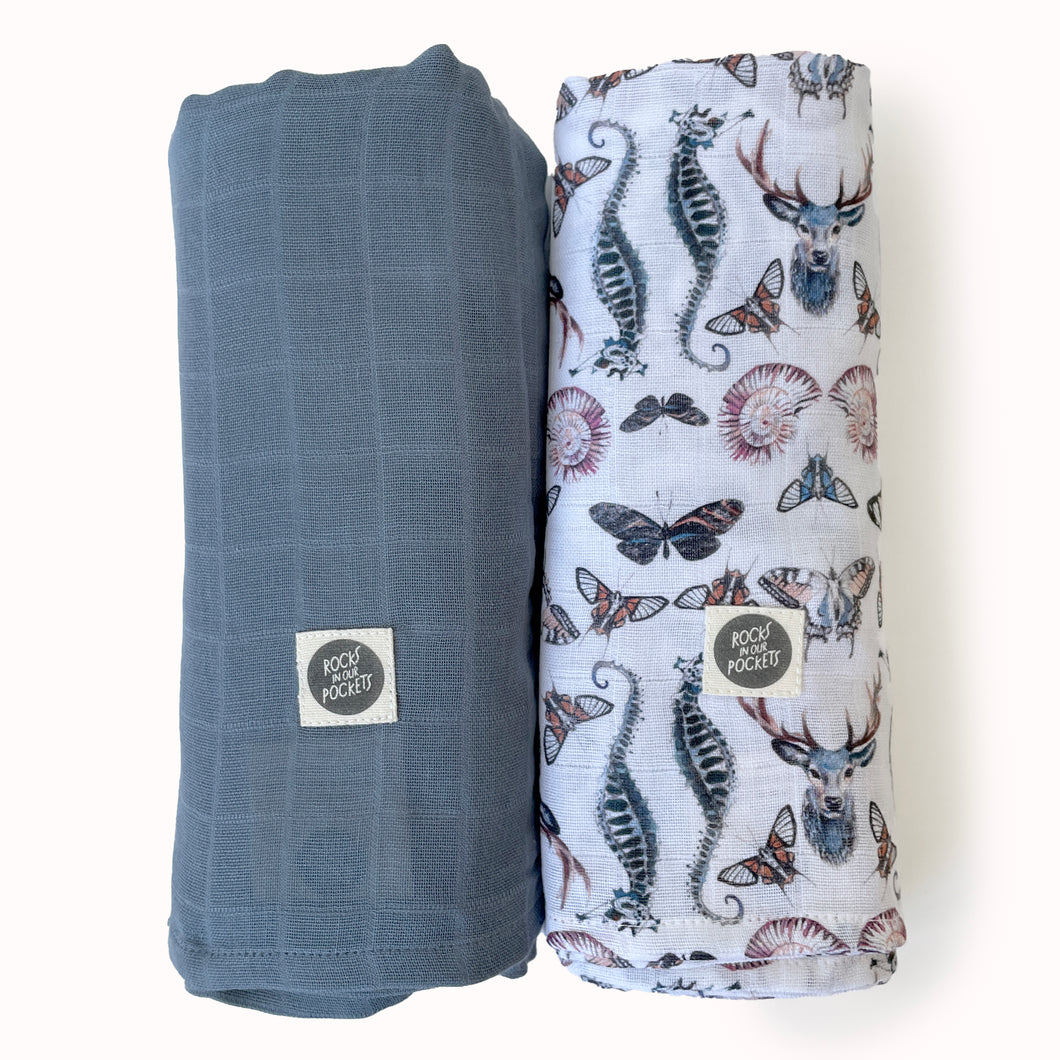 pack of 2 baby muslin swaddle cloths in GOTS certified organic cotton. One printed swaddle, one plain, in gender neutral colours