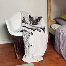 Load image into Gallery viewer, butterfly printed baby receiving blanket draped over a white rocking chair
