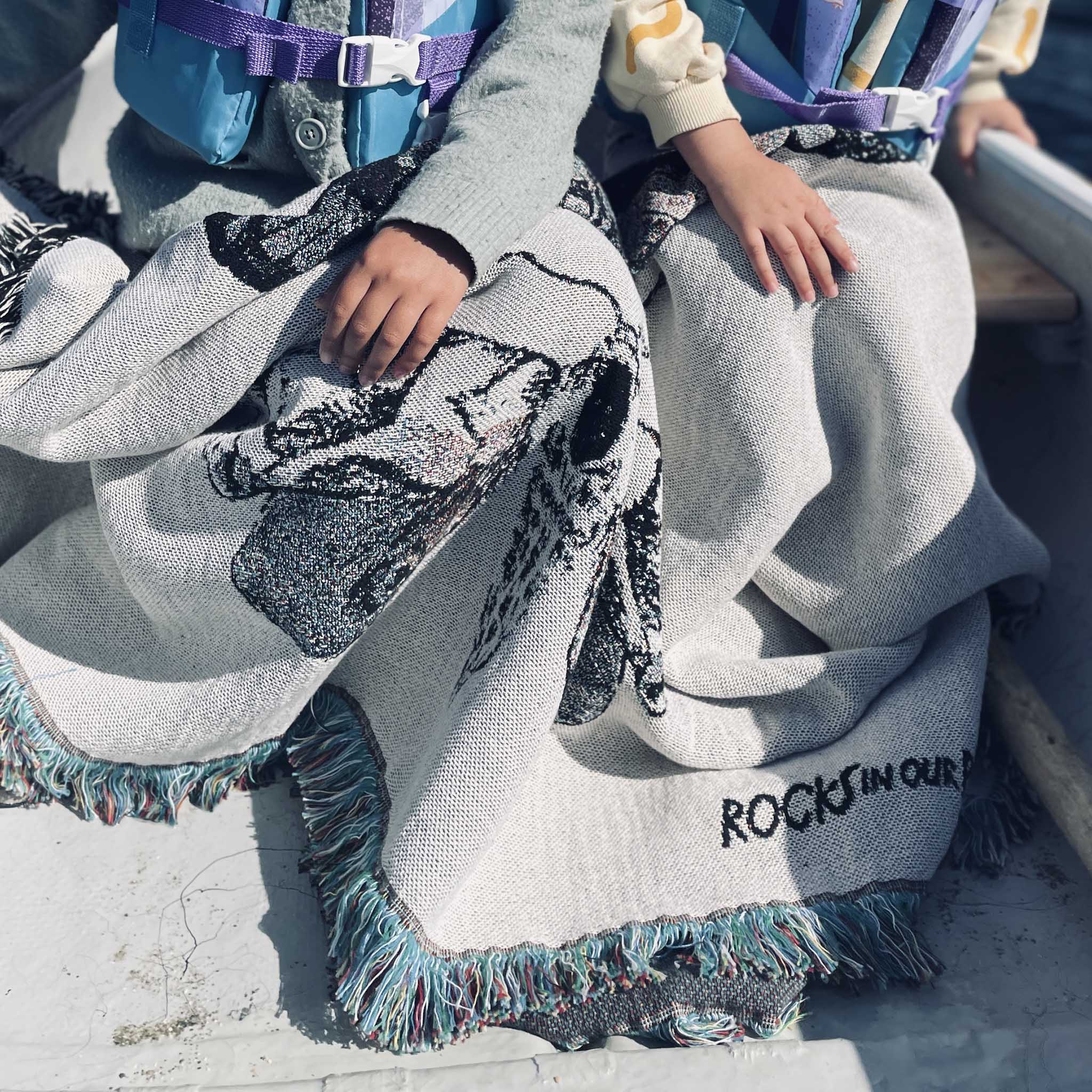 two children out-and-about in a canoe with moth print luxury recycled cotton throw blanket